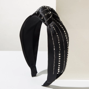 Fashionable black satin knotted headband with shiny silver rhinestones on white base
