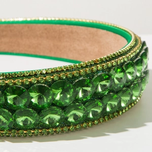 Macro detail of emerald green baroque headband with double row sparkling crystal rhinestones