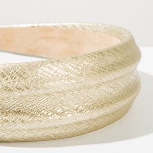 Close-up detail of the golden snakeskin texture and thick padding on the wide headband