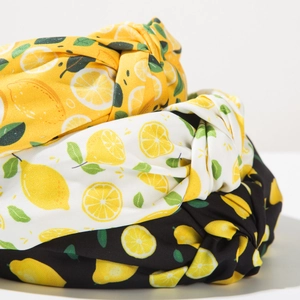 Dettaglio di cerchietti con stampa di limoni e nodi in colori giallo, bianco e nero