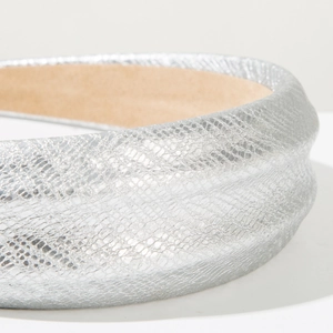 Detailed macro view of silver snakeskin embossed headband with soft brown inner lining
