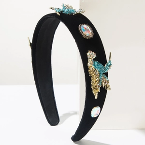 Detailed macro view of baroque velvet headband with blue rhinestone bird and gems