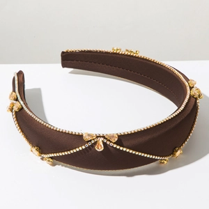 Detail of wide padded brown satin headband with sparkling champagne pear rhinestones