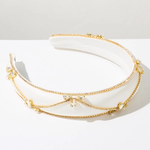 Macro shot of white satin headband with gold chain and sparkling crystal accents