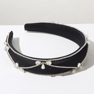 Detailed macro view of black satin headband with bow shape rhinestone decorations