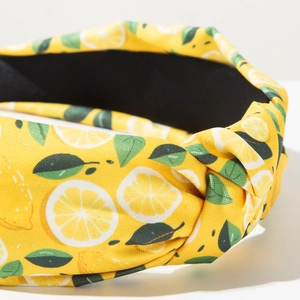 Dettaglio ravvicinato del cerchietto giallo con stampa di limoni e nodo a torsione