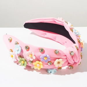 Close-up of pink fabric knotted headband featuring colorful 3D flowers and rhinestones