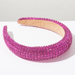 Gros plan sur les strass magenta et la doublure beige du serre-tête rembourré épais