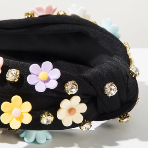 Detail of black knotted headband featuring colorful resin flowers and crystal rhinestones