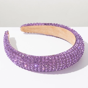 Détail de strass violets étincelants sur un serre-tête rembourré en velours