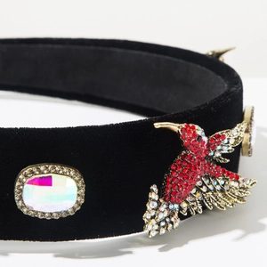 Macro detail of vintage baroque velvet headband with hummingbird and rhinestones
