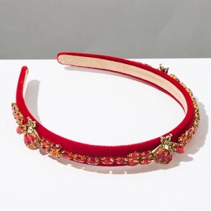 Close-up of red velvet headband featuring ruby crystals and golden bee ornaments