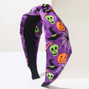 Dettaglio del cerchietto di Halloween in tessuto viola con zucca, teschio e nodo