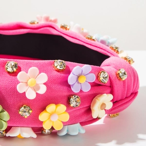 Macro shot of rose pink knotted headband with resin flowers and sparkling crystals