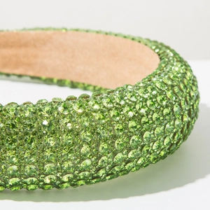 Vue détaillée du serre-tête éponge vert orné de rangées de strass verts brillants