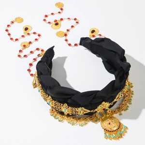 Détail du serre-tête vintage avec tressage noir, pendentifs dorés et pompons