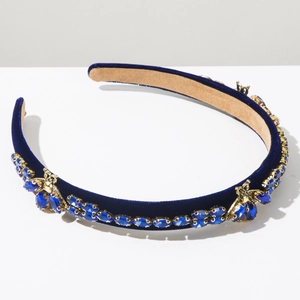 Macro view of blue velvet headband with crystal beads and golden insect jewelry detail