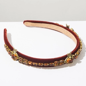 Detailed view of burgundy velvet headband with amber crystals and golden bees