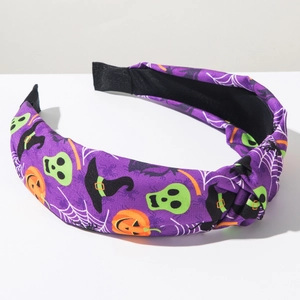 Dettaglio del cerchietto viola per Halloween con zucche, teschi e stampe di ragnatela