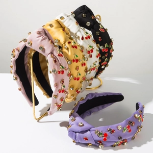 Détail de serre-têtes en satin avec broderie cerise et strass en plusieurs couleurs