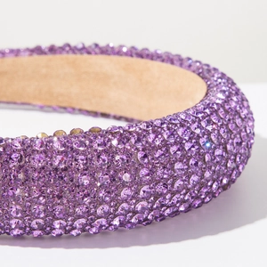 Gros plan de strass violets étincelants sur un bandeau large en éponge à couronne haute