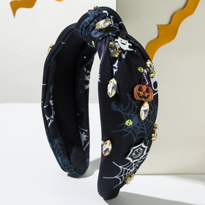 Close-up of Halloween headband featuring spider web print, crystal rhinestones, and pumpkin
