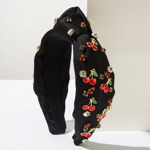 Détail d'un serre-tête noué noir avec des cerises en émail rouge et des strass brillants