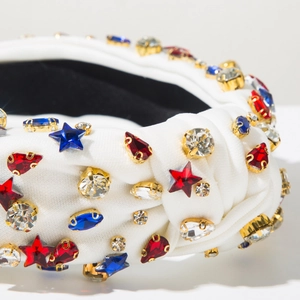 Détail d'un serre-tête blanc noué avec gemmes étoiles rouges bleues et perles