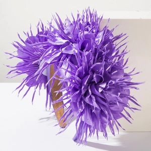 Gros plan détaillé d'un serre-tête en satin violet avec fleurs effilées et strass argentés