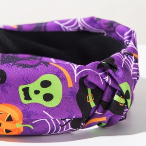 Dettaglio del cerchietto di Halloween in tessuto viola con zucche e teschi stampati