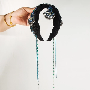 Détail d'un serre-tête vintage noir avec pierres turquoise et longs glands perlés
