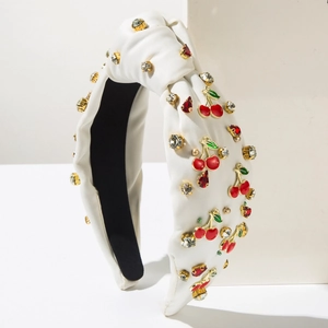 Détail d'un serre-tête en satin blanc avec breloques cerise et doublure noire