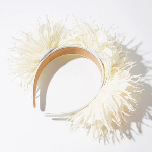 Gros plan détaillé d'un serre-tête en tissu blanc texturé avec des accents de paillettes argentées