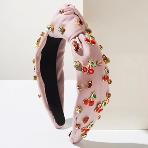 Vue détaillée du serre-tête rose noué avec pendentifs cerises et strass multicolores
