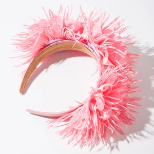 Détail d'un serre-tête en plumes roses avec tissu en soie et cristaux brillants