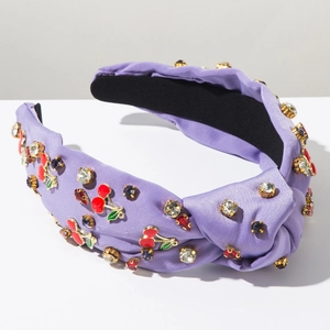 Détail d'un serre-tête en satin violet avec cerises émaillées et strass multicolores