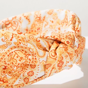 Macro detail of Bohemian paisley print headband with orange and yellow twisted knot style