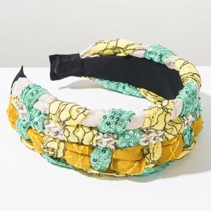 Detail of bohemian braided headband with yellow fabric, green sequins and pearl trim