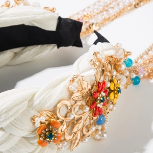 Detail eines gewebten Haarreifs mit floralem Metallbesatz, Emailleblumen und Perlenketten
