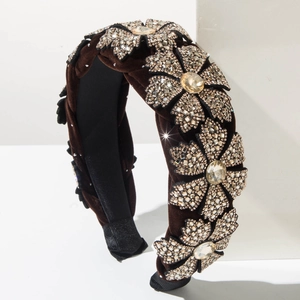 Details von elegantem Samt-Haarreif mit funkelnden Strassblumen und goldfarbenen Kristallen