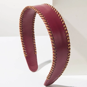 Close-up of burgundy leather headband with elegant gold braided stitching detail