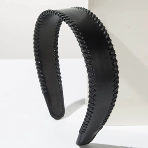 Detail of minimalist black leather headband featuring premium stitched edge and texture