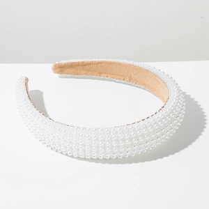 Detail of white pearls on a wide sponge headband with soft camel velvet lining
