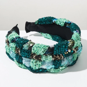 Detailed macro view of woven braided sequins on a wide bohemian green fabric headband