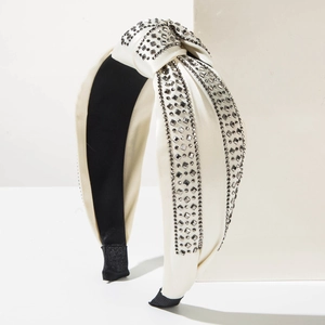 Detailed view of cream satin knotted headband with rows of shimmering grey rhinestones