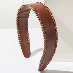 Close-up of brown leather headband featuring decorative beige hand-stitched seam details