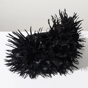 Détail d'un serre-tête floral noir avec texture plumes et strass brillants élégants