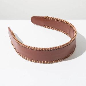 Macro view of brown faux leather headband featuring intricate light stitching details