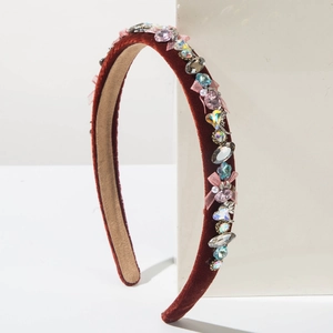 Detail view of burgundy velvet headband with colorful gems, pearls and pink silk bows