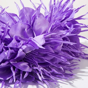 Gros plan détaillé du serre-tête floral en satin violet avec strass et franges plumes